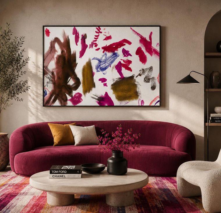 Landscape abstract artwork above a deep red curved sofa